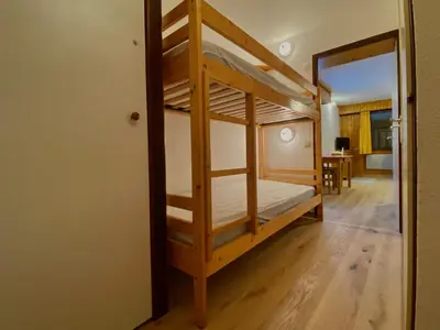 a bunk bed in a room with a doorway at Studio cosy rénové avec balcon et animaux acceptés, centre de Samoëns - FR-1-624-157 in Samoëns