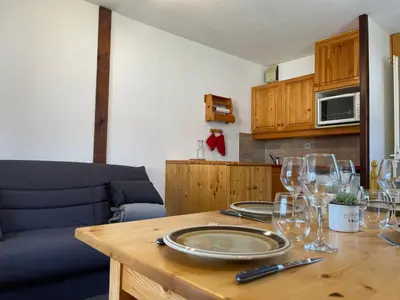 a wooden table with wine glasses on top of it at Studio cosy rénové avec balcon et animaux acceptés, centre de Samoëns - FR-1-624-157 in Samoëns