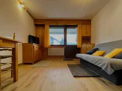 a bedroom with a bed and a large window at Studio cosy rénové avec balcon et animaux acceptés, centre de Samoëns - FR-1-624-157 in Samoëns