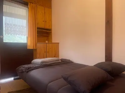 a bed in a bedroom with a window at Studio cosy rénové avec balcon et animaux acceptés, centre de Samoëns - FR-1-624-157 in Samoëns