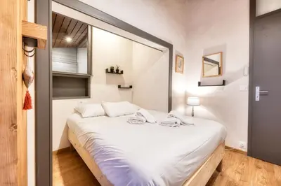 a bedroom with a large white bed with a large window at Luméa - Chalet vue sur le Mont Blanc in Saint-Gervais-les-Bains