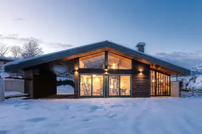 a house with glass doors in the snow at Luméa - Chalet vue sur le Mont Blanc in Saint-Gervais-les-Bains