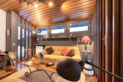 a living room with a couch and a table at Luméa - Chalet vue sur le Mont Blanc in Saint-Gervais-les-Bains