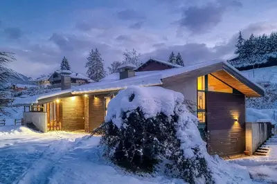 a house covered in snow at night at Luméa - Chalet vue sur le Mont Blanc in Saint-Gervais-les-Bains