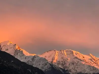 a group of snow covered mountains under a sunset at Luméa - Chalet vue sur le Mont Blanc in Saint-Gervais-les-Bains