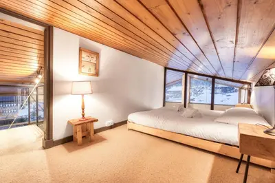 a bedroom with a bed with a wooden ceiling at Luméa - Chalet vue sur le Mont Blanc in Saint-Gervais-les-Bains