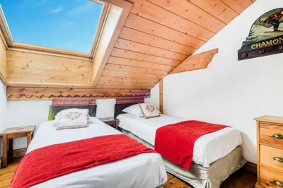 two beds in a room with wooden ceilings at Résidence La Ginabelle - maeva Home - Appartement 4 Pièces 8 Personnes - Sélection MAE-1965 in Chamonix-Mont-Blanc