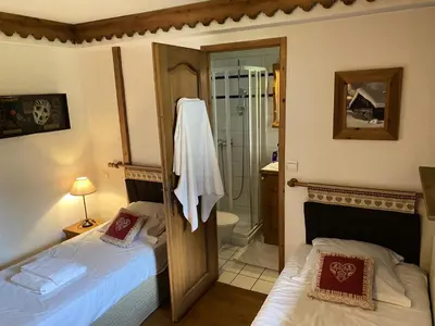 two beds in a room with a shower and a bathroom at Résidence La Ginabelle - maeva Home - Appartement 3 pièces 6 personnes - Sélection MAE-2964 in Chamonix-Mont-Blanc
