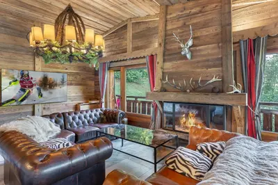 a living room with leather furniture and a fireplace at SOMPTUEUX CHALET BARON MEGEVE VUE.Jaccuzi.4 mn a pied au centre in Megève