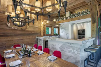 a dining room with a table and a chandelier at SOMPTUEUX CHALET BARON MEGEVE VUE.Jaccuzi.4 mn a pied au centre in Megève