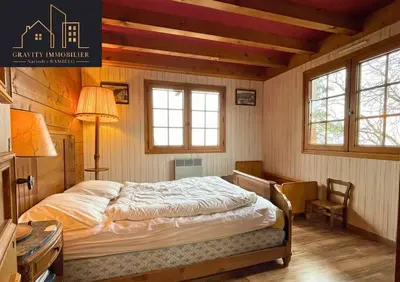 a bedroom with a bed and a desk and windows at Chalet 4 pièces + Mezzanine , Les Carroz in Les Carroz d'Araches