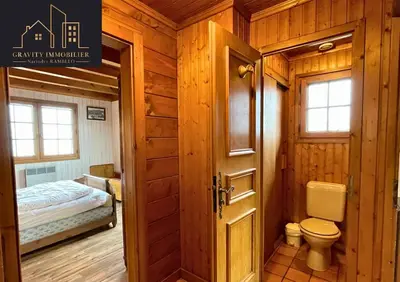 a bathroom with a toilet and a bed in a room at Chalet 4 pièces + Mezzanine , Les Carroz in Les Carroz d'Araches