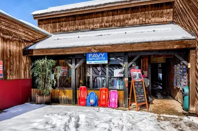 a store with a sign on the front of it in the snow at Village Club Les Tavaillons in Les Carroz d'Araches