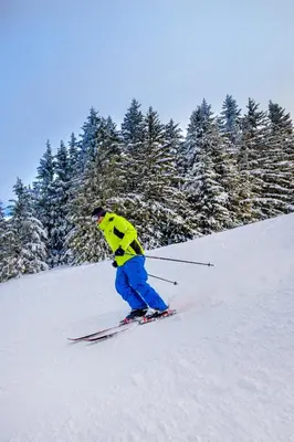 a person is skiing down a snow covered slope at Village Club Les Tavaillons in Les Carroz d'Araches