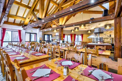 a large dining room with wooden tables and chairs at Village Club Les Tavaillons in Les Carroz d'Araches