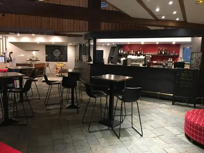a restaurant with tables and chairs and a bar at Village Club Les Tavaillons in Les Carroz d'Araches