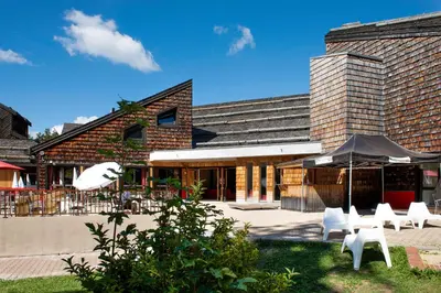 a group of white chairs in front of a building at Village Club Les Tavaillons in Les Carroz d'Araches