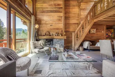 a living room with a fireplace and wooden walls at Appartement Chalet à Megève in Megève