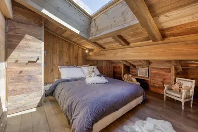 a bedroom with a large bed in a room with wooden walls at Appartement Chalet à Megève in Megève