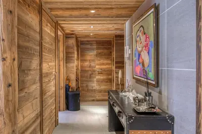 a hallway with wood paneled walls and a black desk at Appartement Chalet à Megève in Megève