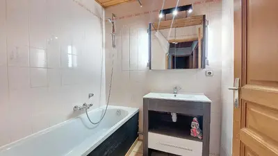 a bathroom with a tub and a sink and a bath tub at Appartement 1 chambre idéalement situé in Domancy