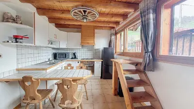 a kitchen with a table and some wooden stools at Appartement 1 chambre idéalement situé in Domancy