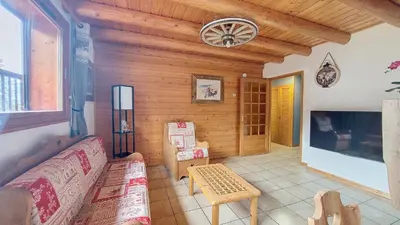 a living room with a couch and a tv at Appartement 1 chambre idéalement situé in Domancy
