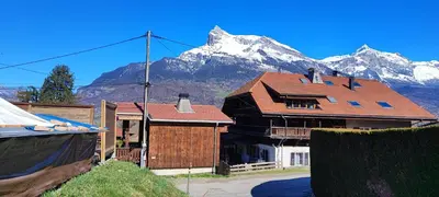 a house with a mountain in the background at Appartement 1 chambre idéalement situé in Domancy