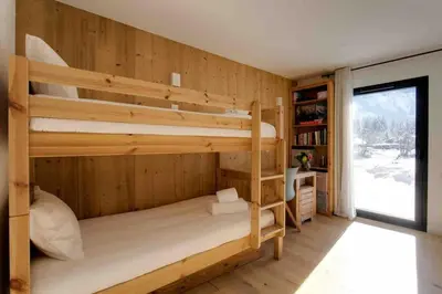 a bedroom with two bunk beds and a window at La Belle Cordee SPA lujo y piscina CHAMONIX in Chamonix-Mont-Blanc