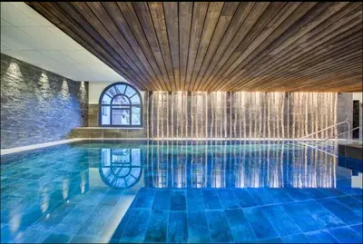 a large swimming pool with a wooden ceiling at La Belle Cordee SPA lujo y piscina CHAMONIX in Chamonix-Mont-Blanc