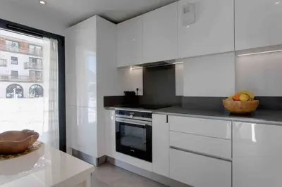 a kitchen with white cabinets and a counter top at La Belle Cordee SPA lujo y piscina CHAMONIX in Chamonix-Mont-Blanc