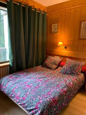 a bedroom with a bed and a window with curtains at appartement T2 pour 6 personnes à Combloux in Combloux