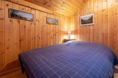 a bedroom with a blue bed in a wooden room at Alpine Escape Facing the Aiguille du Midi in Chamonix-Mont-Blanc