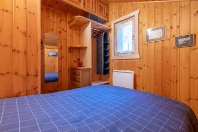 a bedroom with a blue bed in a wooden room at Alpine Escape Facing the Aiguille du Midi in Chamonix-Mont-Blanc