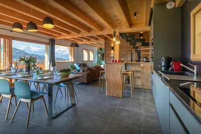 a kitchen and living room with a table and chairs at Chalet Chantalhys - OVO Network in Saint-Gervais-les-Bains