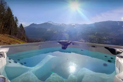 a hot tub with a view of the mountains at Chalet Chantalhys - OVO Network in Saint-Gervais-les-Bains