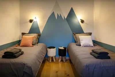 two beds in a room with mountains painted on the wall at Chalet Chantalhys - OVO Network in Saint-Gervais-les-Bains