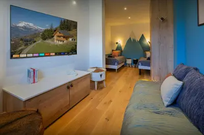 a living room with a couch and a tv on the wall at Chalet Chantalhys - OVO Network in Saint-Gervais-les-Bains