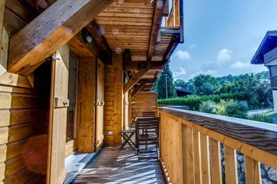 a porch of a log cabin with stools on it at Apartment Chalet des Granges in Les Houches