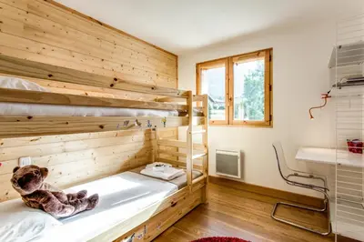 a room with two bunk beds and a window at Apartment Chalet des Granges in Les Houches