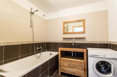 a bathroom with a tub and a washing machine at Apartment Chalet des Granges in Les Houches