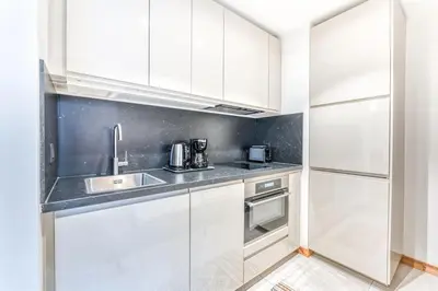 a kitchen with white cabinets and a sink at Barrats Studio - modern with Mont Blanc view in Chamonix-Mont-Blanc