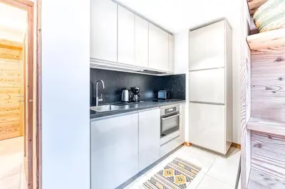 a kitchen with white cabinets and a sink at Barrats Studio - modern with Mont Blanc view in Chamonix-Mont-Blanc