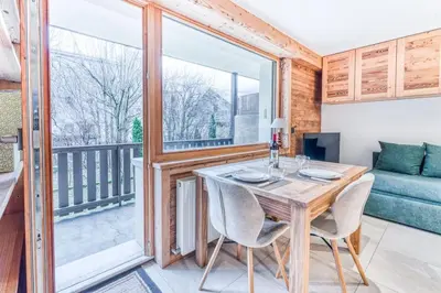 a dining room with a table and chairs and a balcony at Barrats Studio - modern with Mont Blanc view in Chamonix-Mont-Blanc
