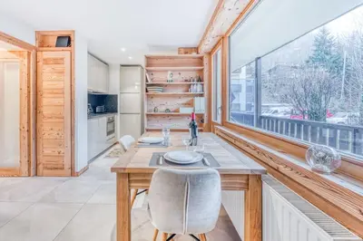 a dining room with a table and a large window at Barrats Studio - modern with Mont Blanc view in Chamonix-Mont-Blanc