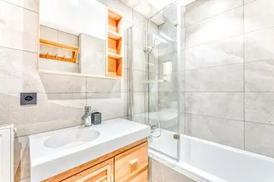 a bathroom with a white sink and a shower at Barrats Studio - modern with Mont Blanc view in Chamonix-Mont-Blanc