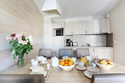 a dining room table with a vase of flowers and fruit at Résidence Odalys Le Panoramic in Flaine