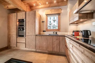 a kitchen with wooden cabinets and a sink at Chalet Inari Chamonix - by EMERALD STAY in Chamonix-Mont-Blanc