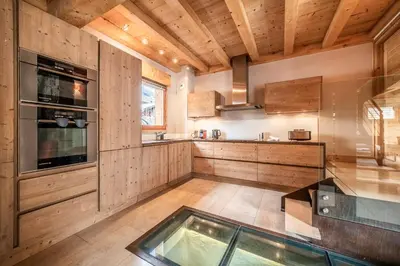 a kitchen with wooden walls and a glass floor at Chalet Inari Chamonix - by EMERALD STAY in Chamonix-Mont-Blanc
