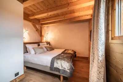 a bedroom with a bed in a room with wooden ceilings at Chalet Inari Chamonix - by EMERALD STAY in Chamonix-Mont-Blanc